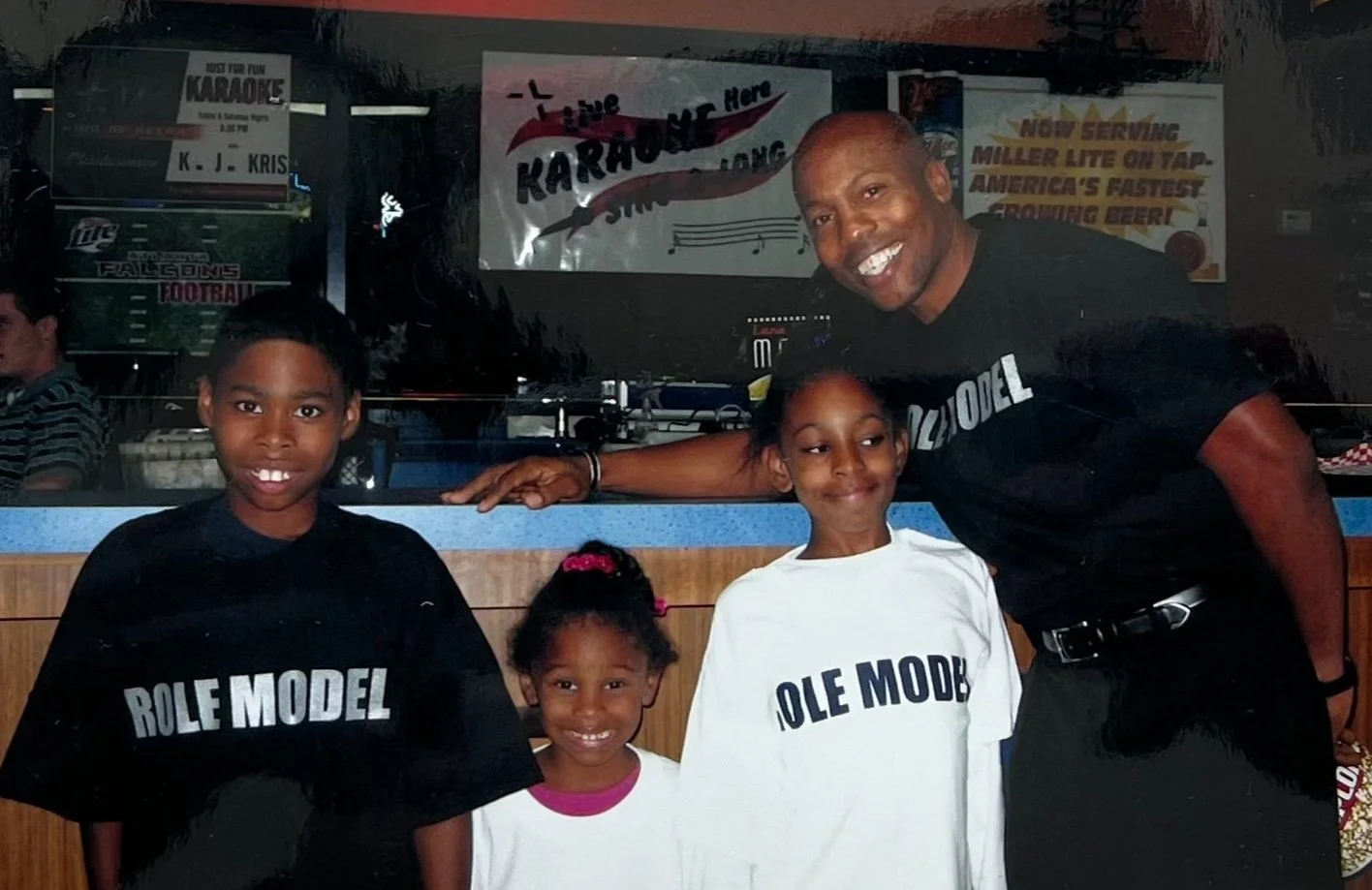 Founder Robert L. Releford with three young people wearing Role Model shirts