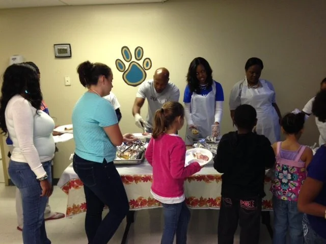Volunteers serving a warm Thanksgiving meal to families
