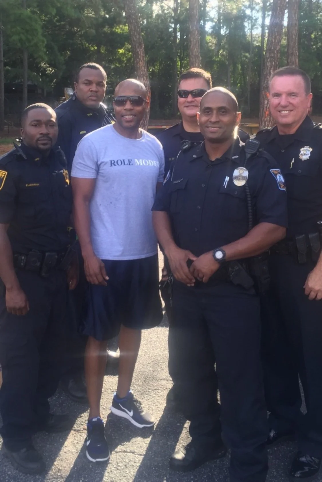 Founder Robert L. Releford in a Role Model shirt with local police officers and sheriff's deputies